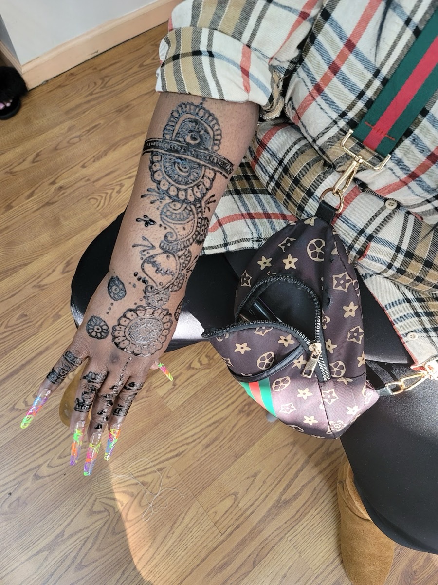 Intricate henna art running up the hand and forearm